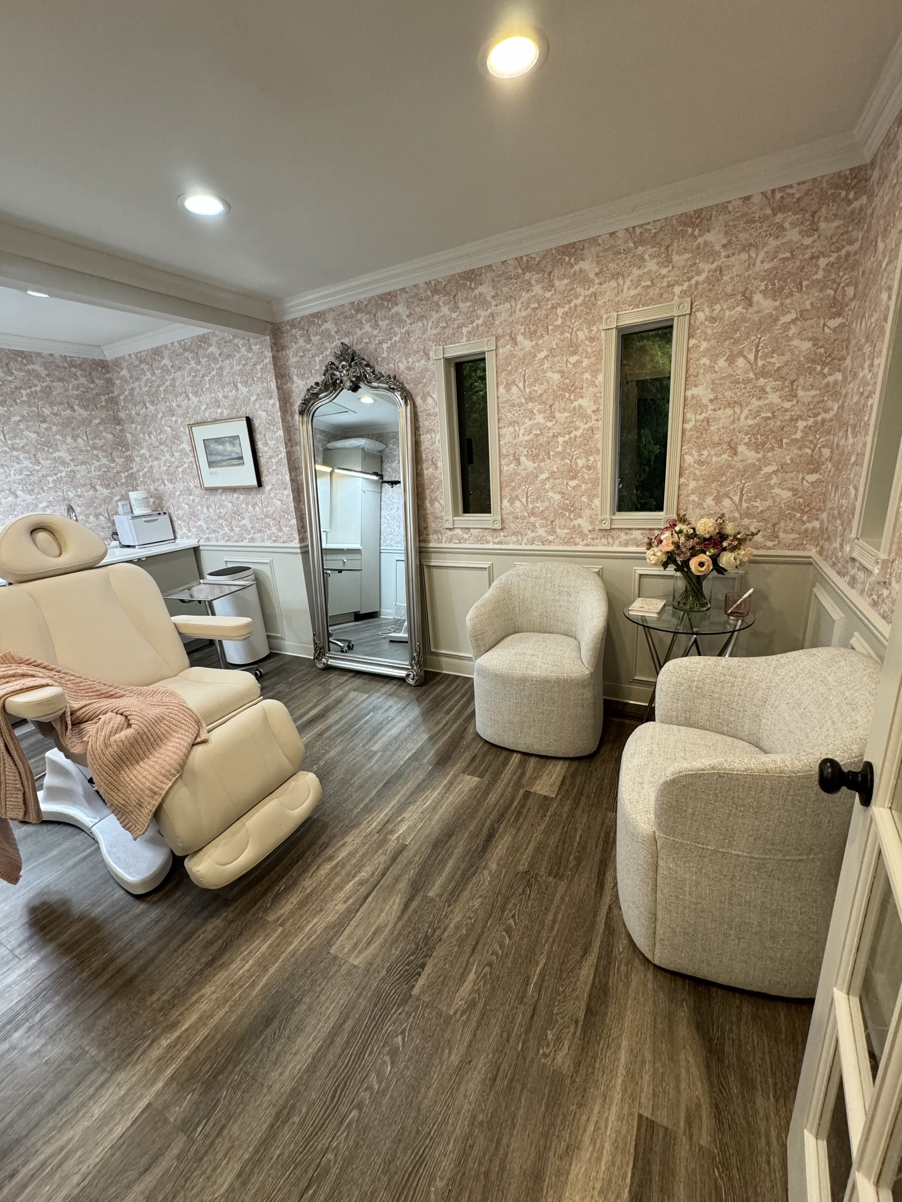 Treatment room at Glammed Up Aesthetics with a treatment chair and soft ivory seating